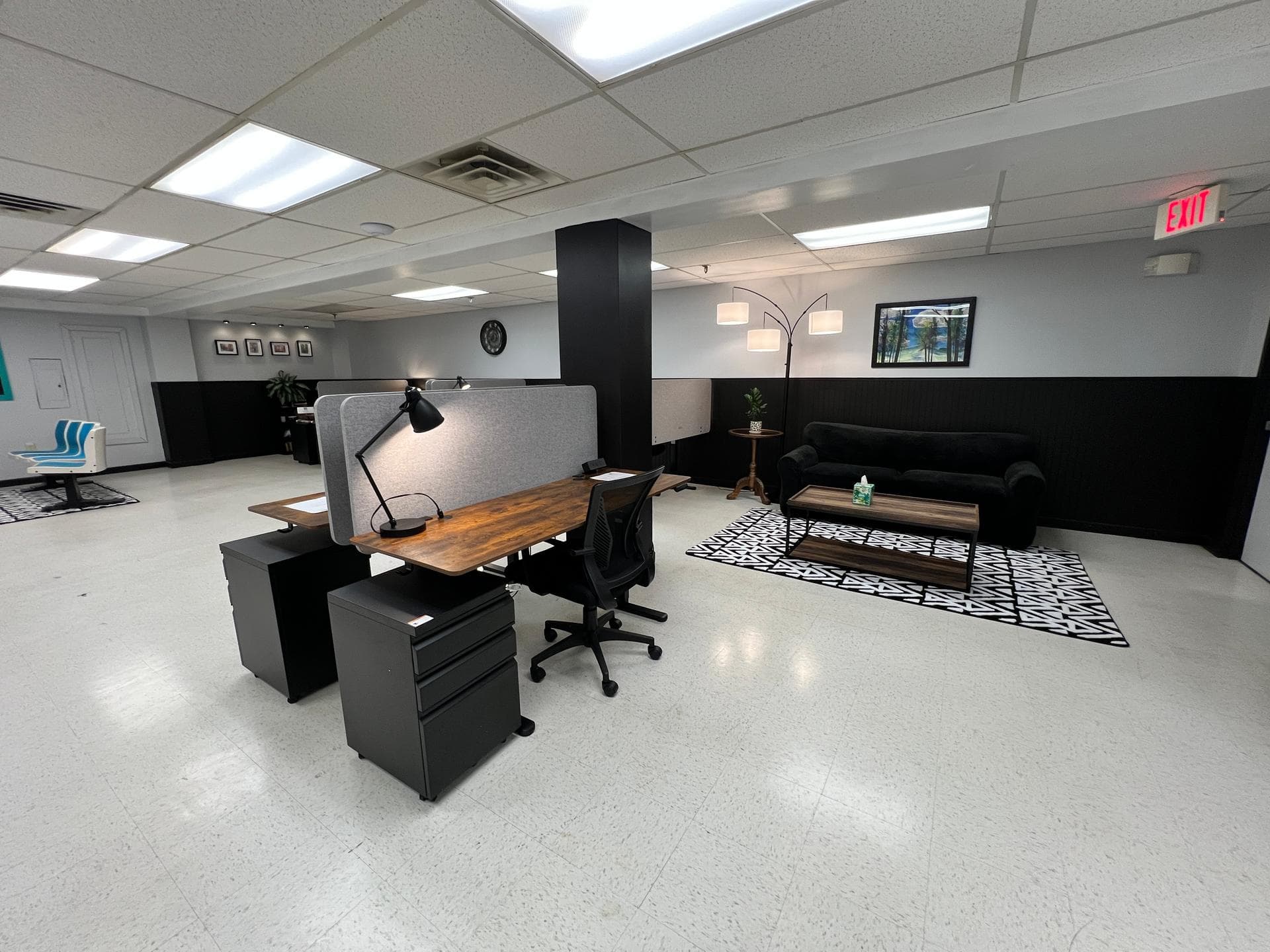 Modern coworking space interior featuring ergonomic standing desks, comfortable lounge seating, and bright natural lighting