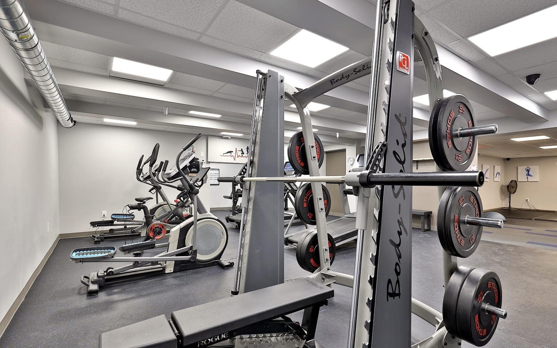 Fully equipped fitness center with free weights, cardio machines, and modern exercise equipment